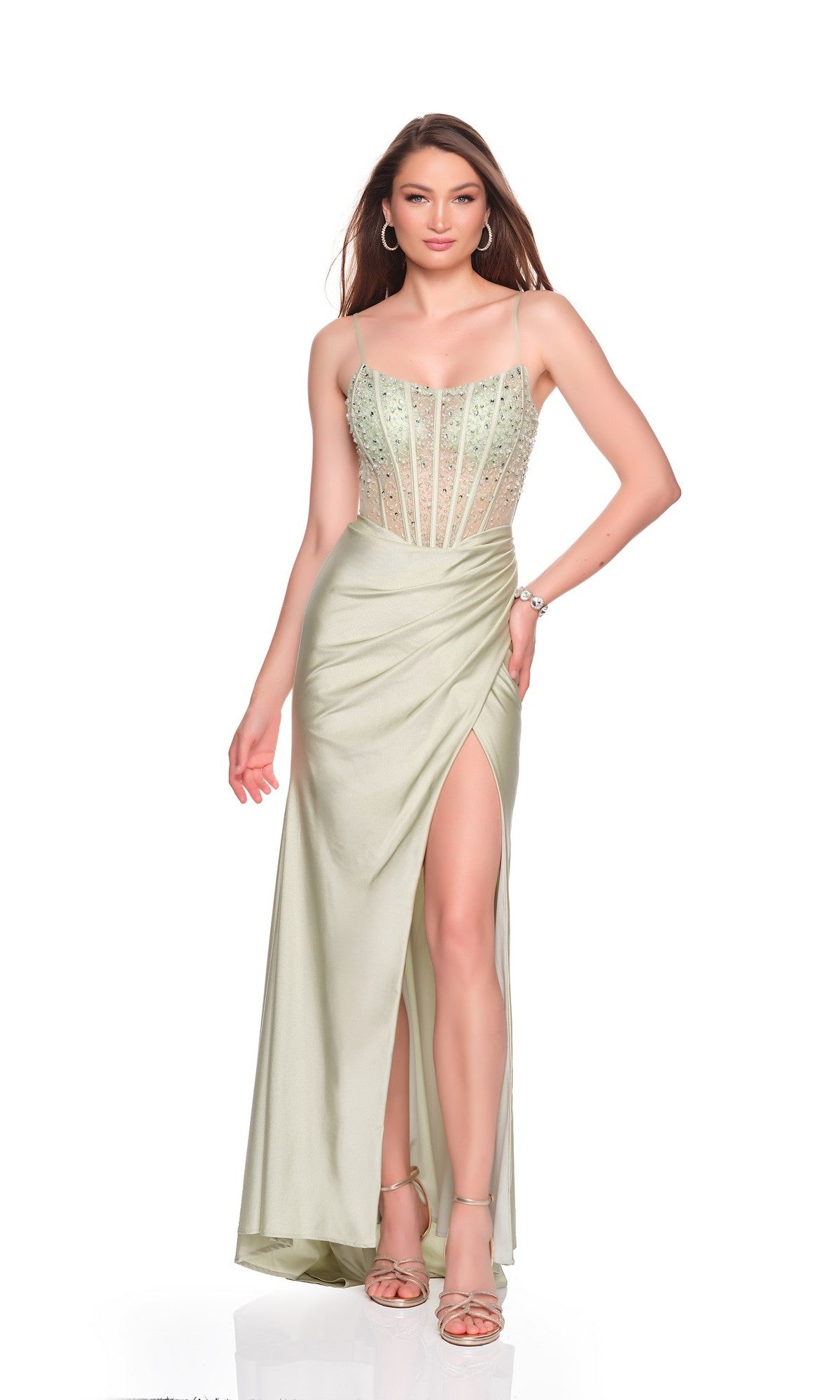 A woman poses in the Long Prom Dress: Dave and Johnny 12704, which features a beaded, semi-sheer corset bodice, spaghetti straps, a sheath skirt with a high slit, and strappy heels against a white background.